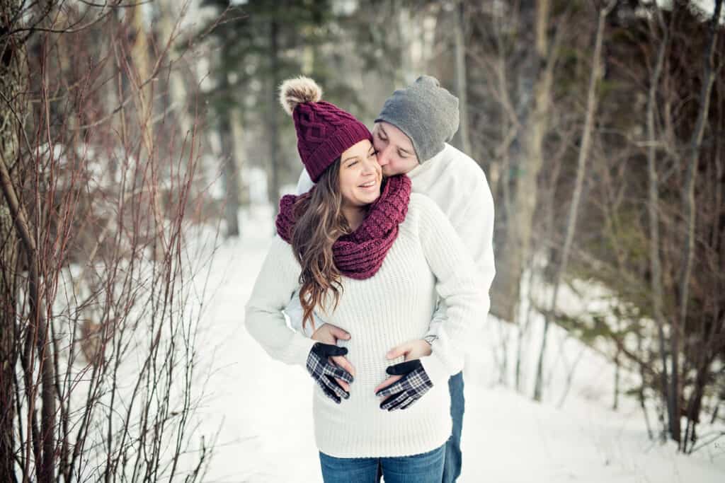 Pregnant couple have fun in winter nature
